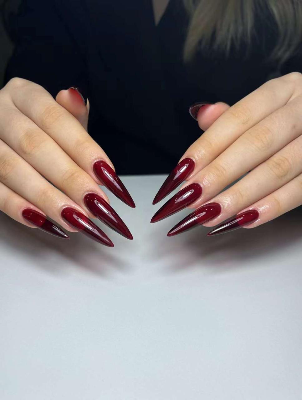 Deep maroon glossy stiletto nail set sculpted at The Nail Box Academy